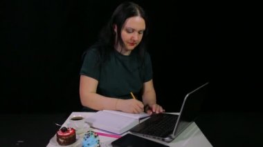 Bir kafede pensive kadın bir bilgisayar ile çalışır ve bir kafede kahve içecekler