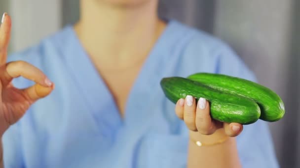 In vrouwelijke handen groene komkommers. Hand toont OK — Stockvideo