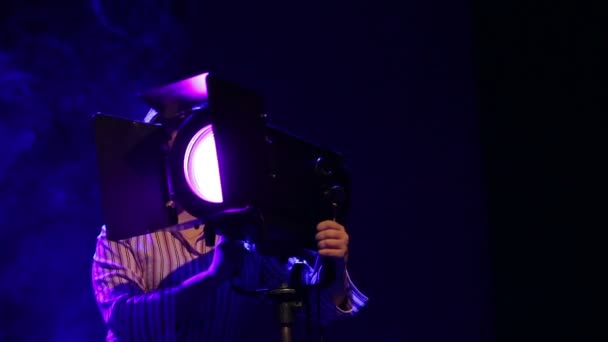 Una donna illuminatrice sul palco lavora con un proiettore di profilo teatrale — Video Stock