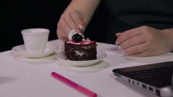 Женские руки на черном фоне в кафе за стаканом выпейте чашечку кофе и ложку с десертом — стоковое видео