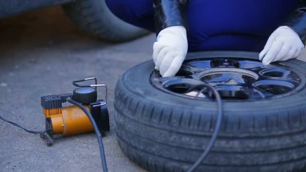 Eldivenli bir kadın diskteki araba lastiğinin kapağını söküyor.. — Stok video
