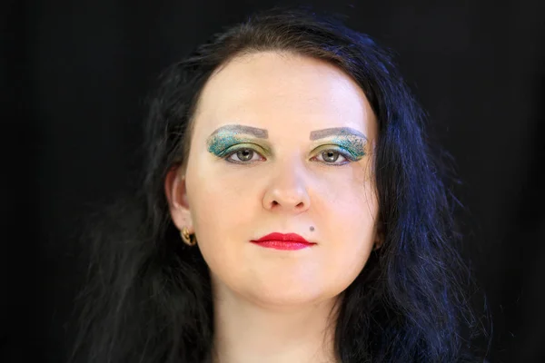 Das Gesicht einer jungen Brünetten mit einem hellen Make-up glasierte Schatten und funkelt — Stockfoto