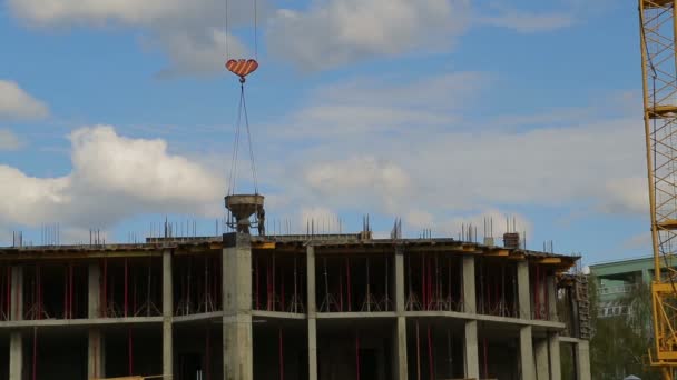Construção com trabalhadores do telhado e um guindaste de torre levantando materiais de construção — Vídeo de Stock