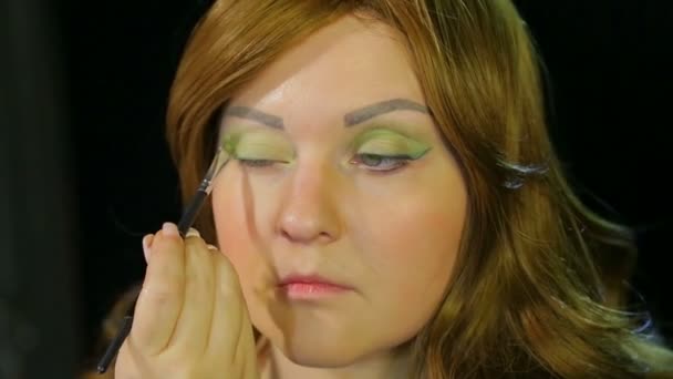 Attrice dai capelli rossi nello spogliatoio fa trucco degli occhi ombre verdi che si preparano a salire sul palco — Video Stock