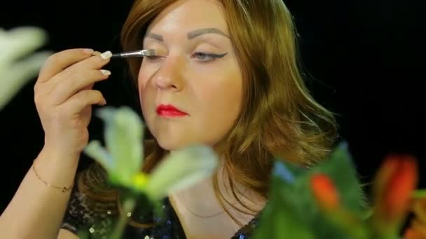 Soyunma odasında kızıl saçlı oyuncu sahneye gitmeye hazırlanan gümüş ışıltılar ile göz makyajı yapıyor — Stok video
