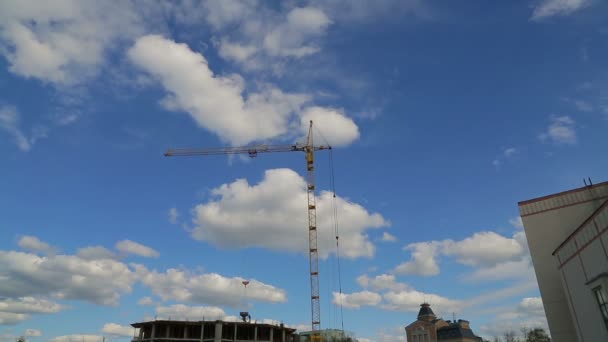 Lavori di costruzione della gru a torre sulla costruzione dell'edificio con i lavoratori sul tetto. Giri temporali — Video Stock