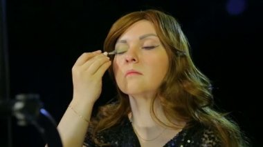 Soyunma odasında ki kızıl saçlı aktris sahneye gitmeye hazırlanıyor.