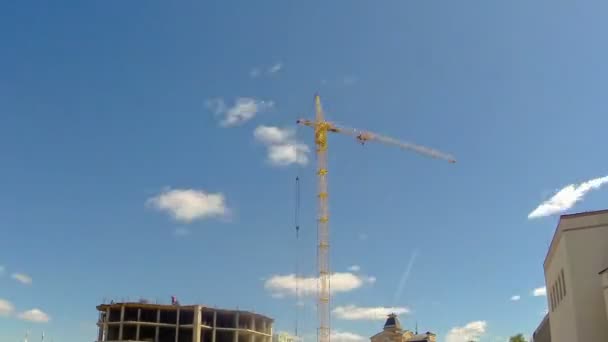 Torre grúa en un sitio de construcción con trabajadores para construir un edificio. Vueltas de tiempo — Vídeos de Stock