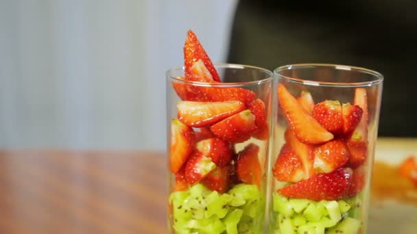 一个女人把玻璃杯里装满了成熟的草莓碎片 — 图库视频影像