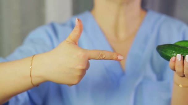 In female hands green cucumbers. A hand is pointing at them — Stock Video