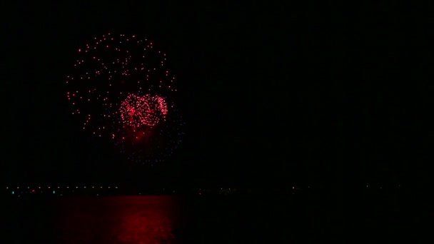 물 위에 반사되는 강 위의 밤하늘에서 불타는 축제 불꽃놀이 — 비디오