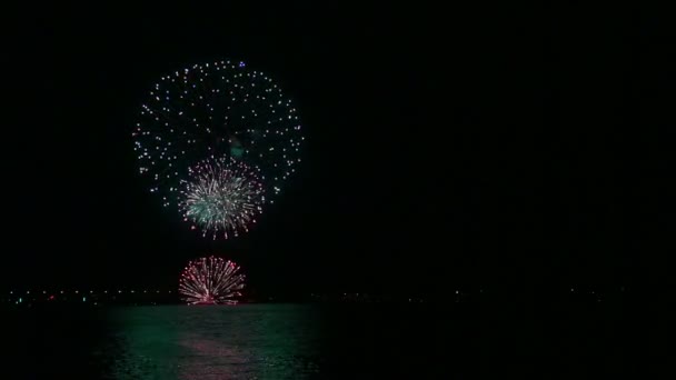 在河上方的夜空中闪闪发光的节日烟花在水里反射 — 图库视频影像