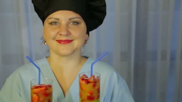 Окуляри зі свіжим фруктовим коктейлем в руках усміхненої кулінарної жінки . — стокове відео