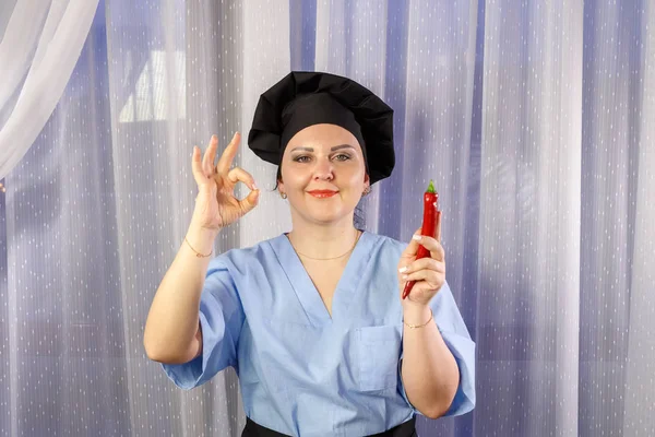 Позитивна жінка готує, тримаючи свіжий червоний перець чилі в руках і показує добре . — стокове фото