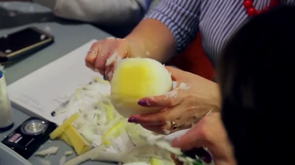 Женские руки режут ножницами пену для игрушек, придавая ей круглую форму — стоковое видео