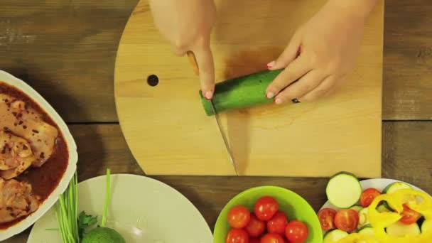Женская рука режет овощи на деревянной доске ножом. Круги времени — стоковое видео