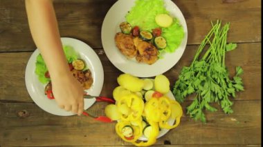 Kadın el salata ile bir plaka ızgara tavuk ve sebze koyar