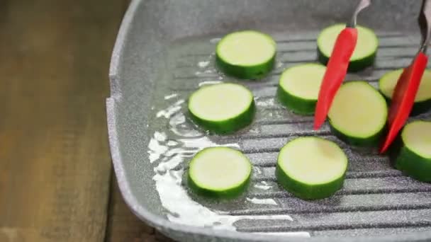 Calabacines verdes se fríen en mantequilla en una sartén . — Vídeos de Stock