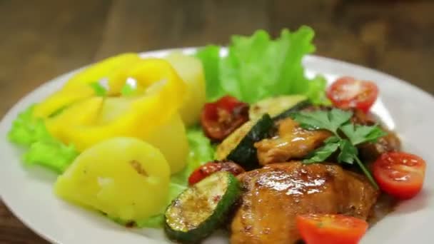 Une assiette rotative avec un plat de poulet grillé et un plat d'accompagnement de légumes — Video