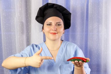 Elinde taze acı biber tutan kadın aşçı.