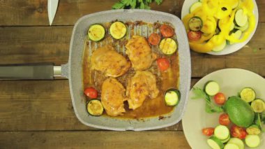 Dişi el ızgara tavada tavuk parçaları sebze koyar. Yukarıdan görüntüle