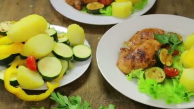 Kadın el Yeşil salata ve tavuk ile bir plaka sebze dilimleri koyar