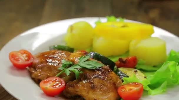 Un plato giratorio con un plato de pollo a la parrilla y un guarnición de verduras — Vídeo de stock