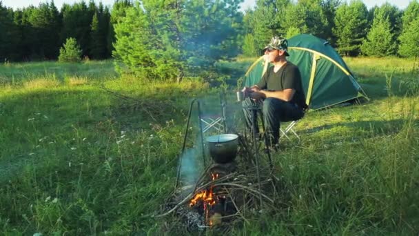 Turyści siedzą w namiocie, picie herbaty — Wideo stockowe