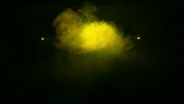 Žluté paprsky světla z reflektorů v kouřové přikrývce. — Stock video