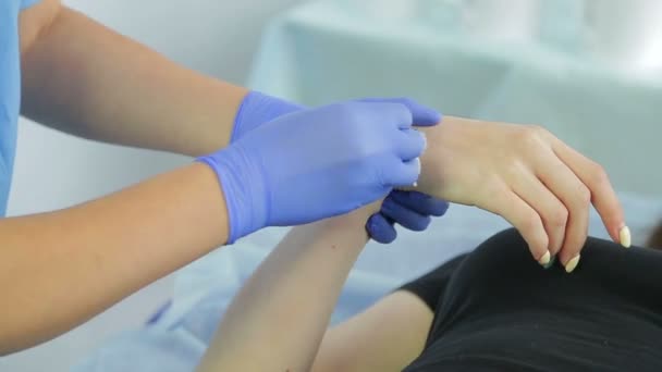 Händerna på den kosmetolog kvinnan gör shugaring av klientens handleder. — Stockvideo