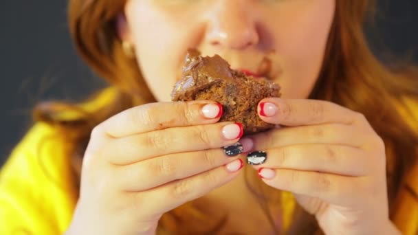 Zrzavá mladá žena po dietě jedí koláče, zatímco nikdo nevidí — Stock video