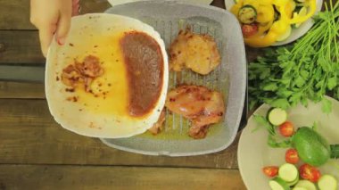 Izgara tavaya tavuk sosu döken kadın el. Zaman turları.