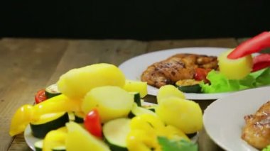 Kadın el Yeşil salata ve tavuk ile bir plaka sebze dilimleri koyar.