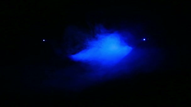 Κατευθύνοντας το φως των μπλε ακτίνων δύο προβολείς προφίλ προς το άλλο σε μια κουβέρτα καπνού. — Αρχείο Βίντεο
