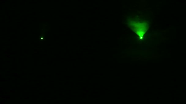 Zielone światło jasnych profili reflektorów w ciemności w kocu dymu. — Wideo stockowe