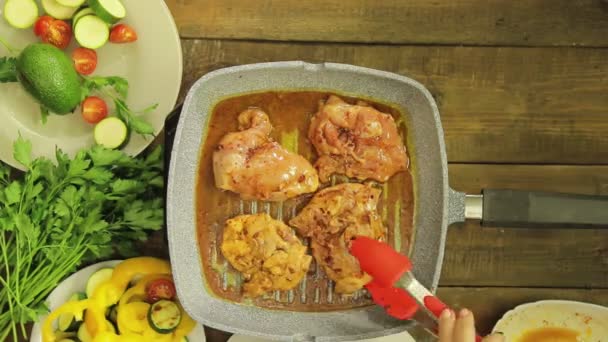 Vrouwelijke hand roeren met Tang kip in een grill pan. Tijd ronden. — Stockvideo