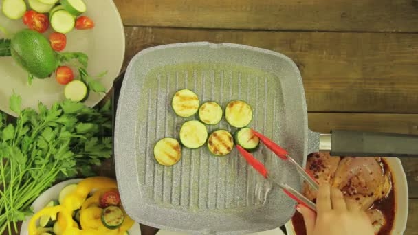 Ung grön zucchini stekt i smör i en grillpanna. — Stockvideo