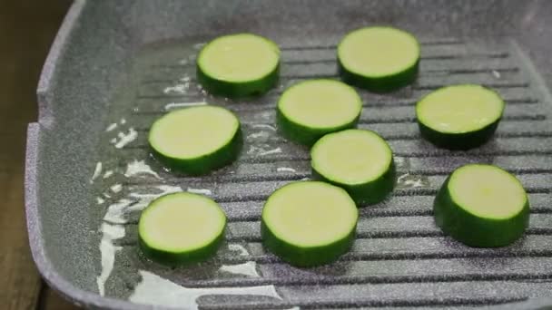 Green courgettes are fried in butter in a grill pan — Stock Video