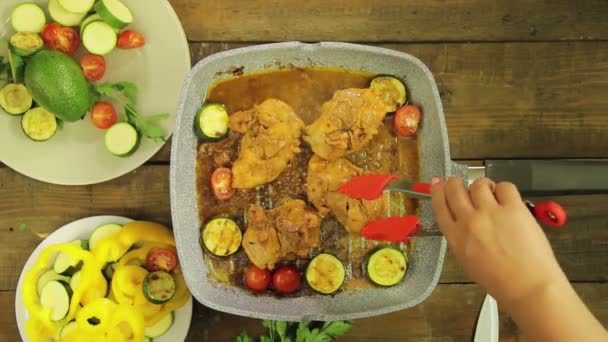 Kvinnlig hand sätter grönsaker i kyckling bitar i en grillpanna. — Stockvideo