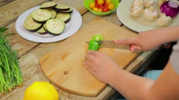 女性は木製のボードにナイフで緑の長い唐辛子をスライスします。タイムラップ — ストック動画