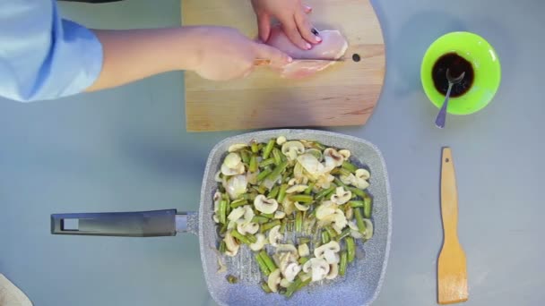 Female hand cuts chicken breast onto plates on wooden board — Stock Video