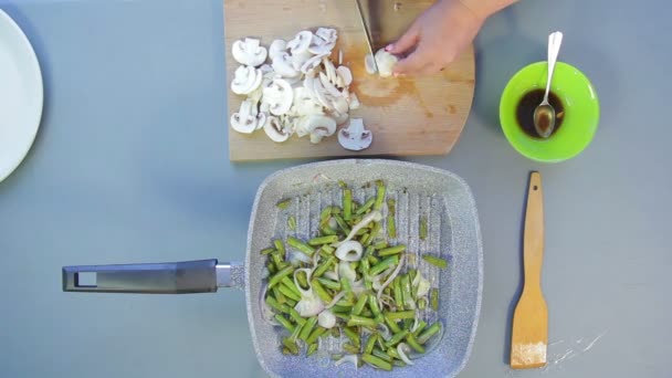 Couper les champignons champignon en tranches à la main sur des assiettes . — Video