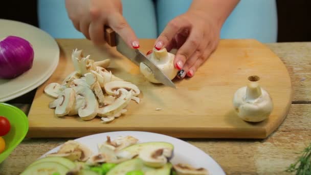 Bir kadın ahşap tahta üzerinde bir bıçak ile dilimleri içine champignon mantar pirzola. — Stok video