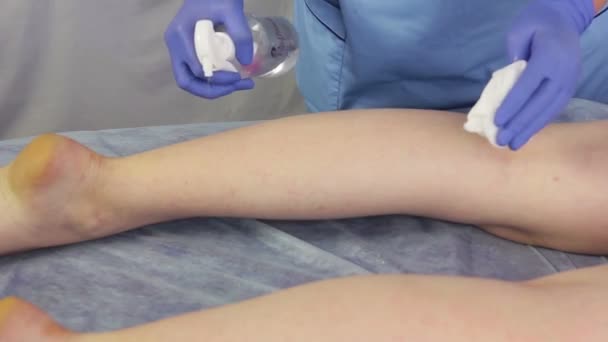 Las manos de la mujer esteticista aplican un spray hidratante a la piel de los pies de la niña . — Vídeos de Stock