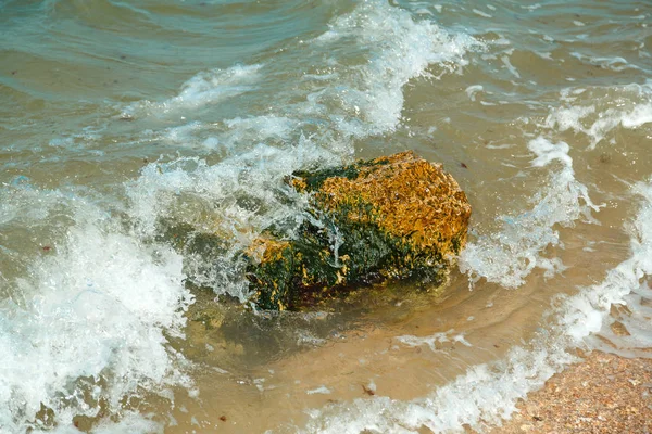 Splashing wave crashing against stones on the seashore with spray. — Stock Photo, Image
