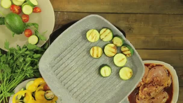As abobrinhas verdes fritam-se na manteiga em uma panela de grelha para decorar ao frango . — Vídeo de Stock