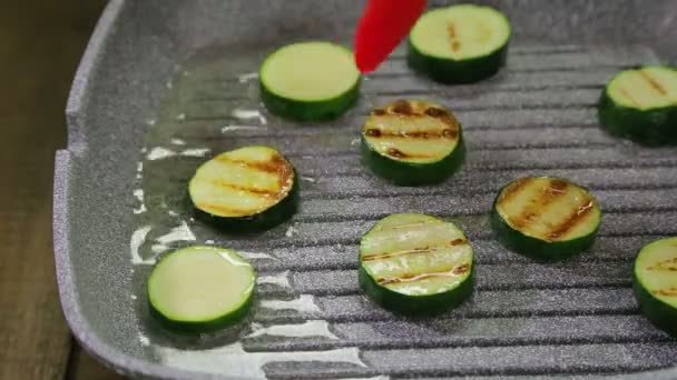 Gröna zucchini är stekt i smör i en grill panna. — Stockvideo