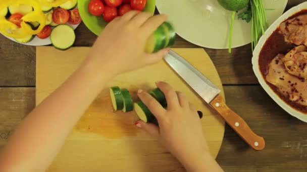 Main féminine met des courgettes tranchées dans une assiette . — Video