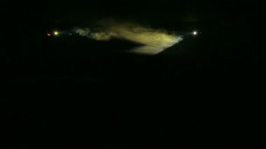 Bir duman battaniyesi karanlıkta profil Spotlar beyaz ışınları. Genel plan