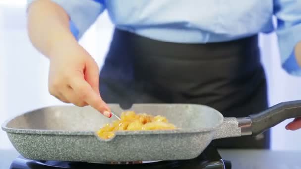 Una mujer mezcla fideos de arroz fritos en una sartén. Vueltas de tiempo . — Vídeos de Stock